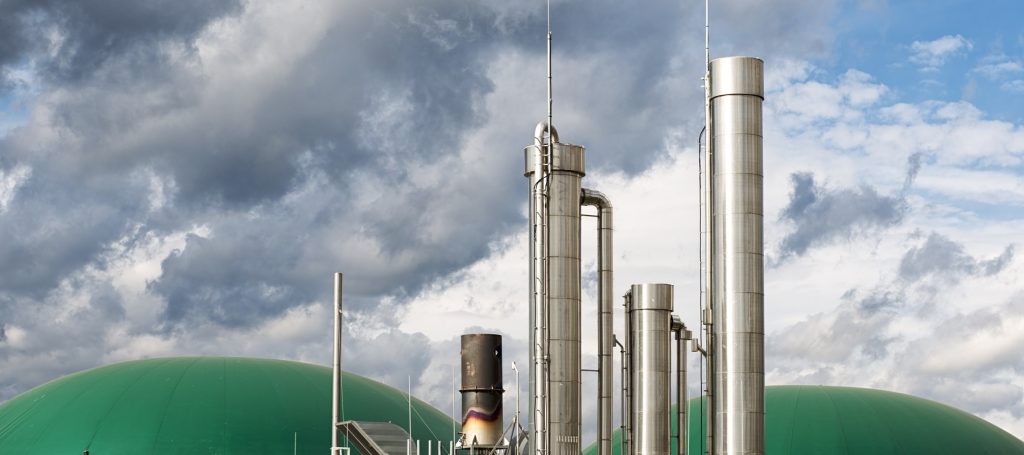 A modern biogas plant under the cloudscape of an approaching thunderstorm.