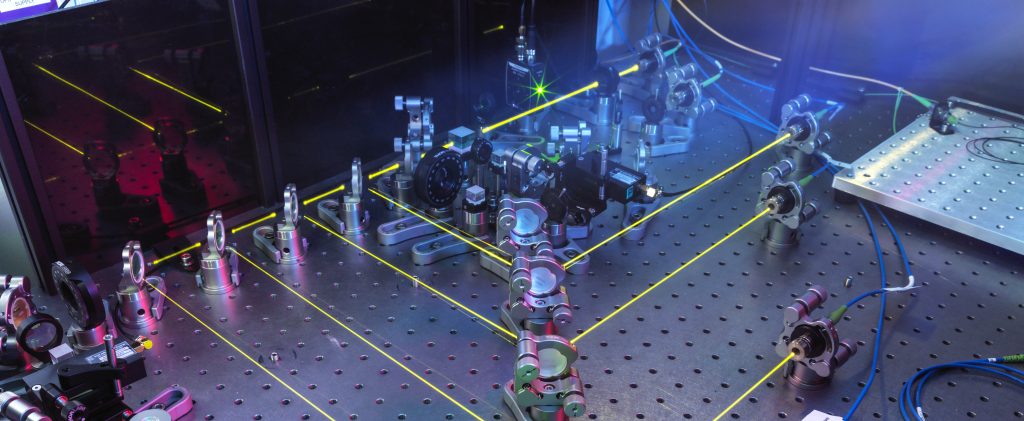 A laser array with several yellow laser beams visible.